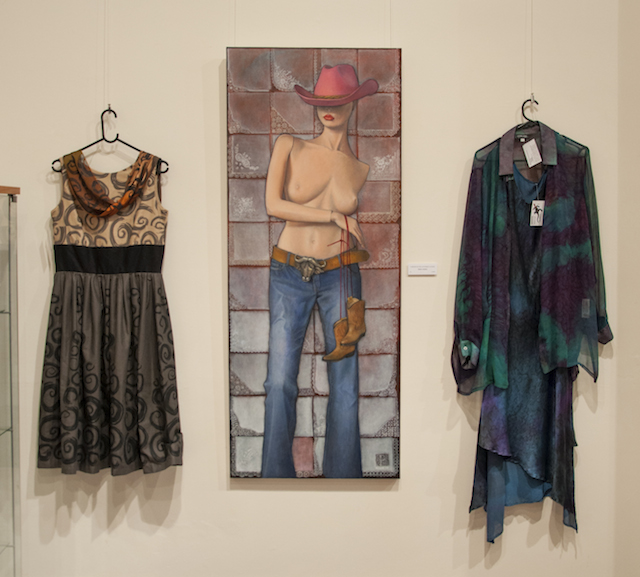 From left, Sandra Shaw’s Rose Dress, hand screened printed cotton $320, and Satin Devore Wrap in silk and rayon hand dyed and screen printed burn out $87.50. Penny Choate’s I Dressed my Doll in Cowboy Clothes. Oil on canvas. $3000. Double Layer Dress of hand painted silk, satin crepe and silk georgette, $250, and Long Sleeved Shirt in hand painted georgette, $250, by Liz Wauchope.