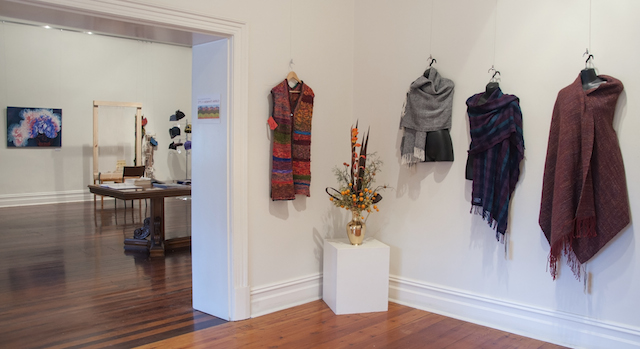 View from Annex into Main Gallery showing Helen Moon’s Knitted Coat of hand painted silk strips $350, and three woven wool shawls by Bev Bills, from left: and Twilled Boucle - $85, Threads - $150, Wrap Up - $170